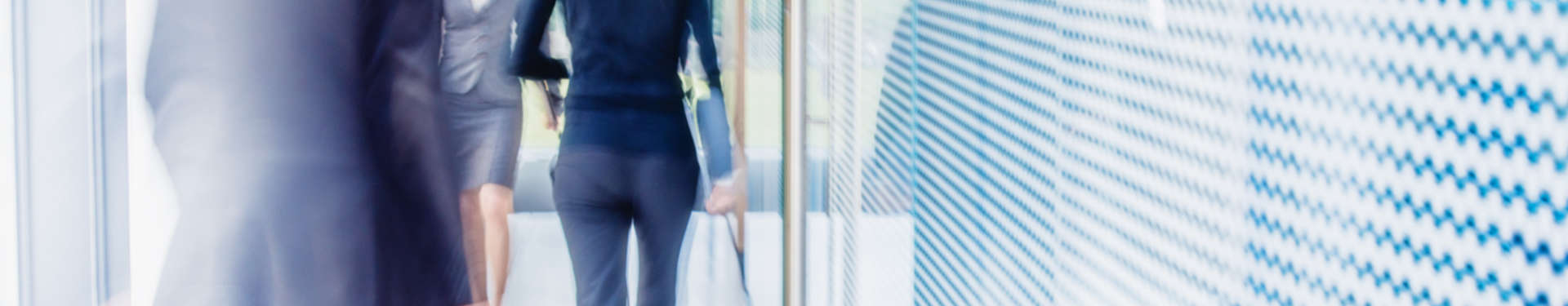 Defocused shot of business people walking in modern office corridor